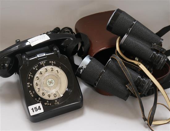 A pair of binoculars and a bakelite telephone